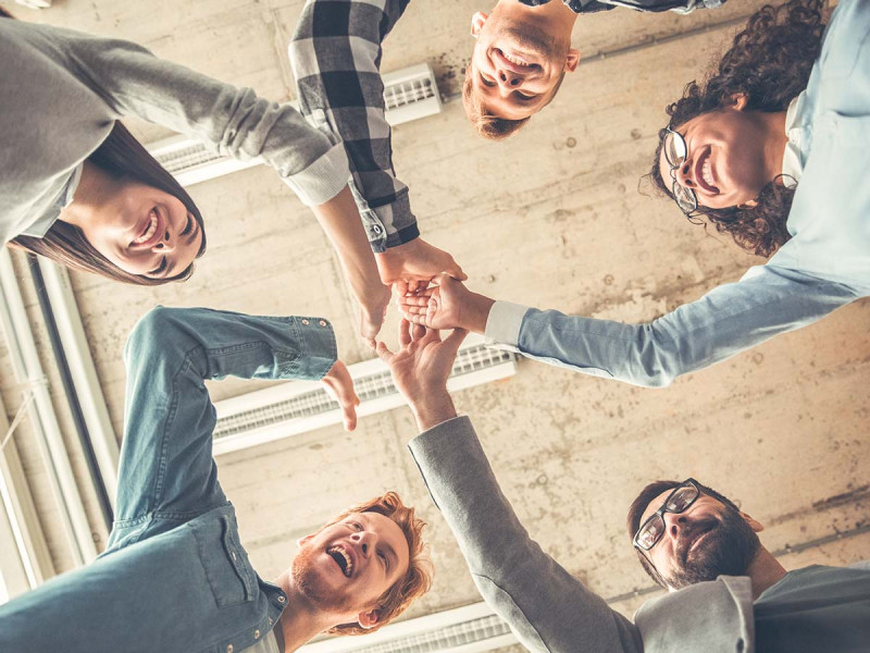 Ein motivierendes Bild, das eine Gruppe von Menschen zeigt, die sich gegenseitig abklatschen. Die Personen stehen in einem Kreis, lächeln und strahlen Freude aus. Diese Szene symbolisiert Teamarbeit, gemeinschaftliche Zielerreichung und die positive Energie, die entsteht, wenn man zusammen ins Handeln kommt. Ideal zur Veranschaulichung von Umsetzungskompetenz und kollektiven Erfolgen.