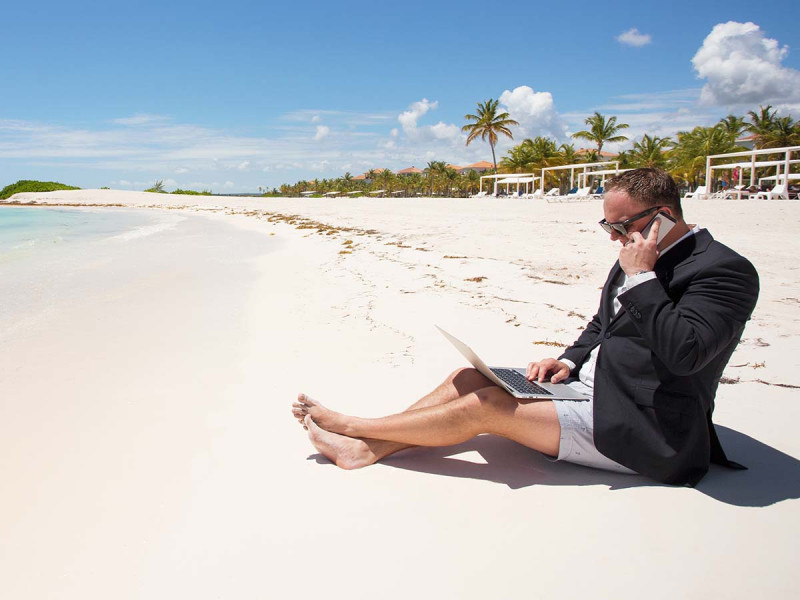 Workaholic am Strand im Urlaub