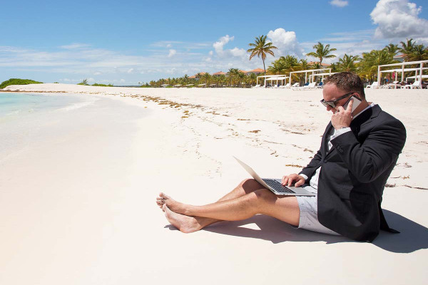 Workaholic am Strand im Urlaub